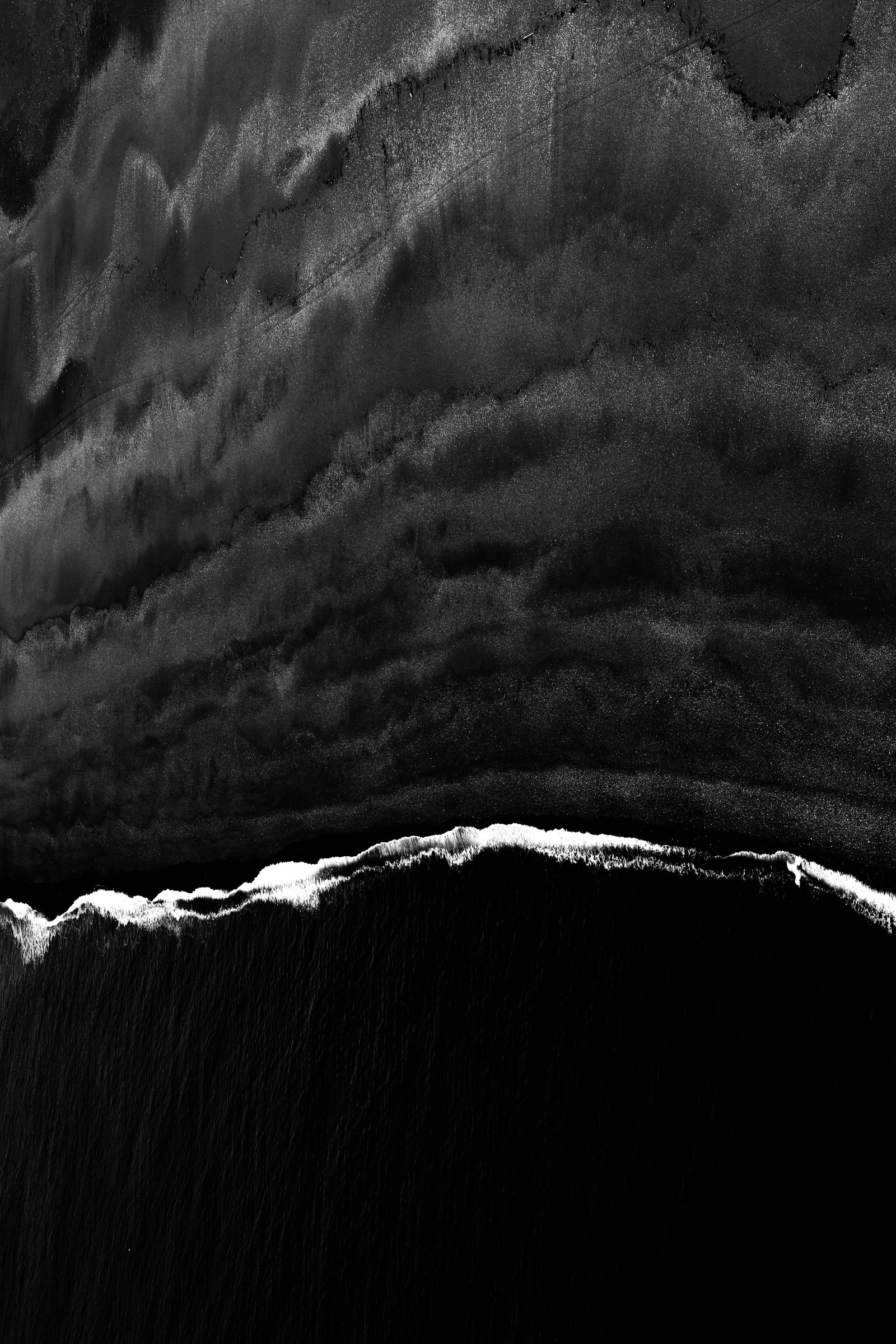 Arena volcánica negra y orilla del Atlántico en las islas Canarias